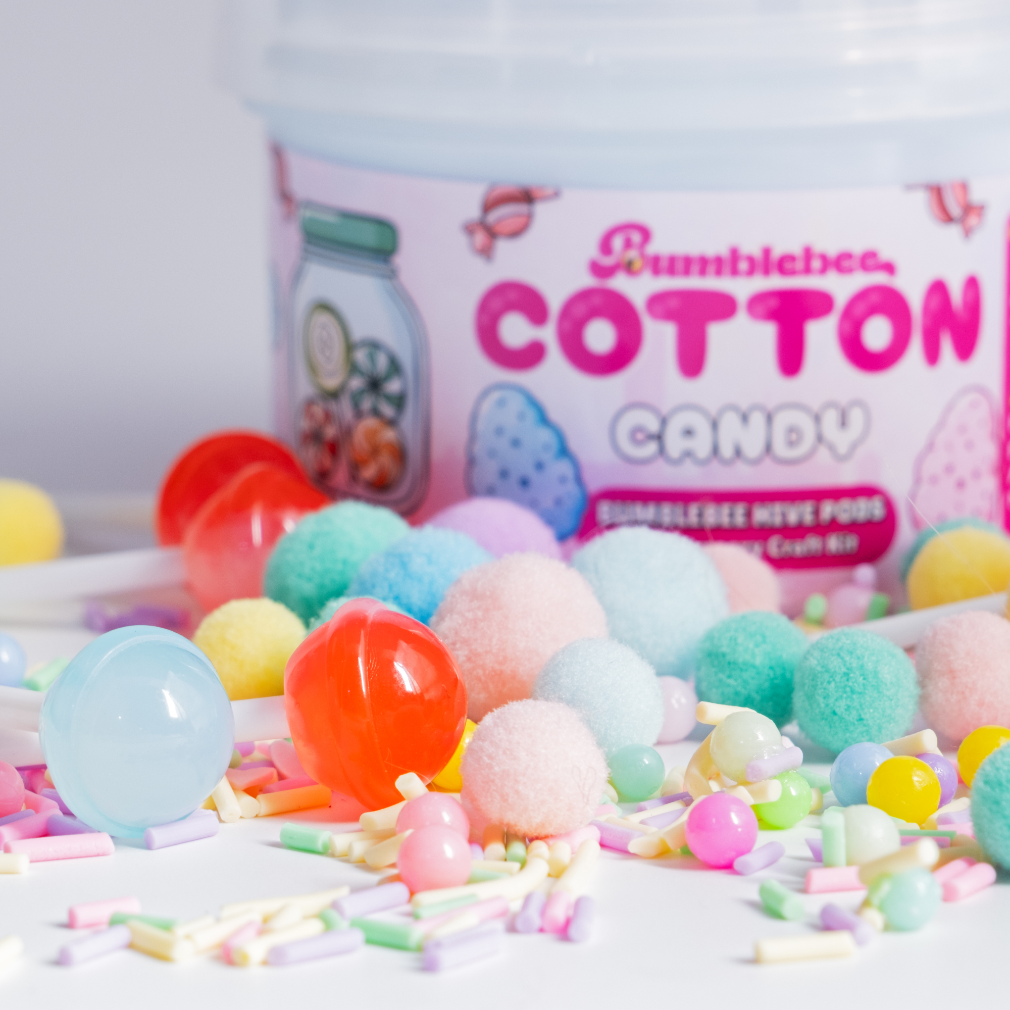 Close-up of the Cotton Candy Hivepod label with pastel pom-poms and candy beads in the foreground