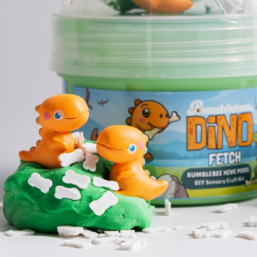 Close-up of two orange dinosaur charms on green Dino Fetch slime with bone-shaped beads