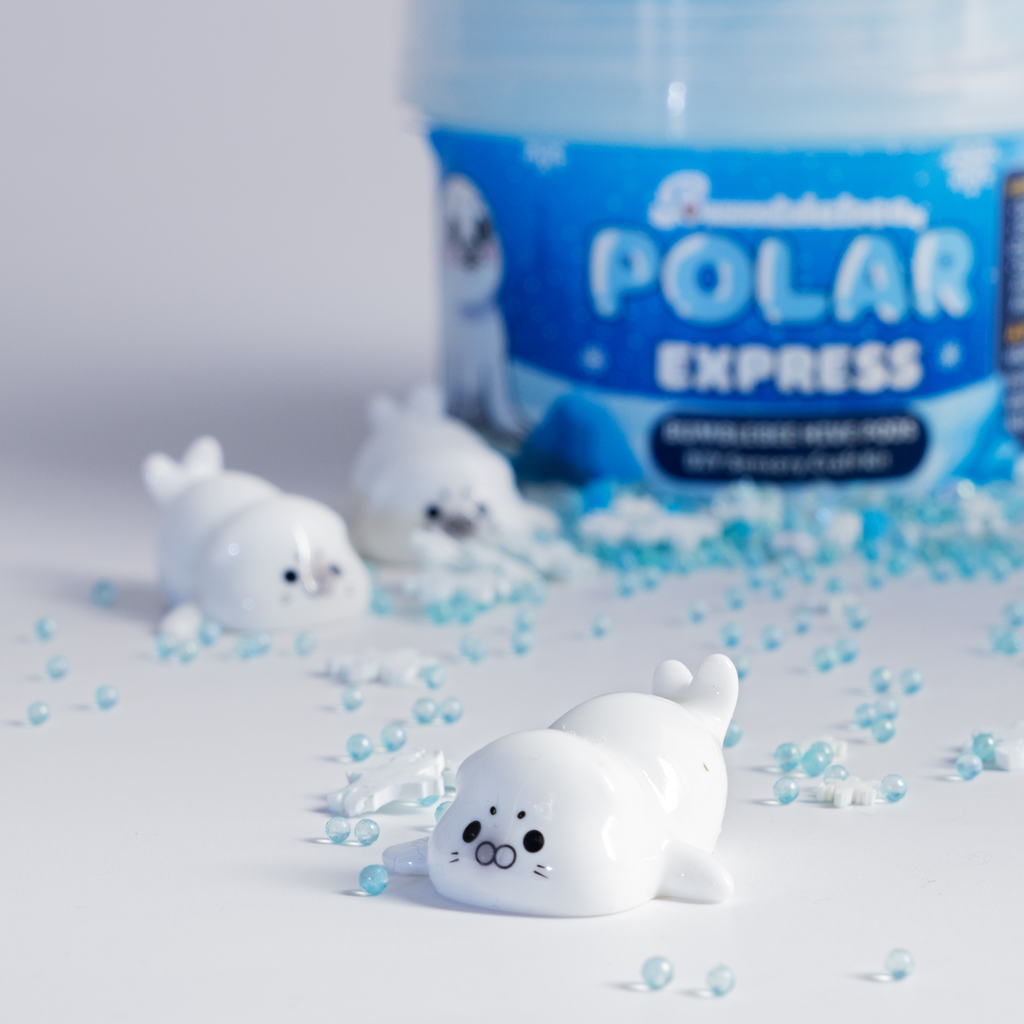 Close-up of a baby seal charm beside the Polar Express Hivepod with blue pearl beads