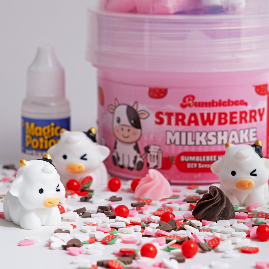 Close-up of the Strawberry Milkshake label with cow charms and strawberry sprinkles in the foreground